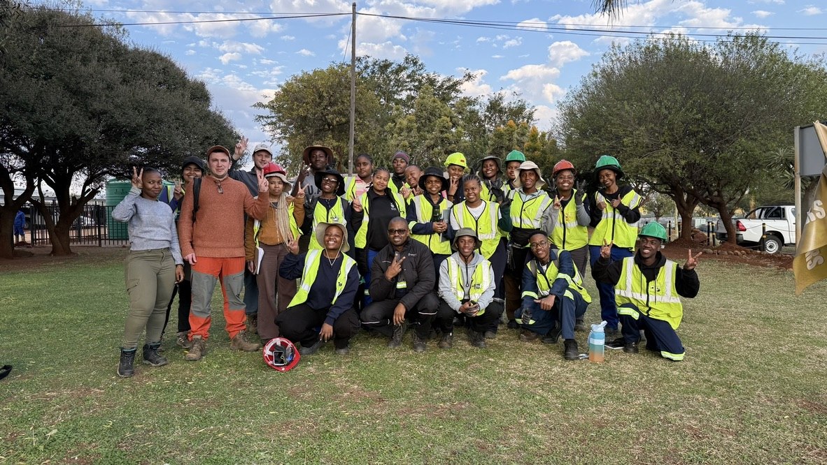 A field course group of students and instructors in hi-vis vests and hard hats, Bushveld Complex, South Africa.