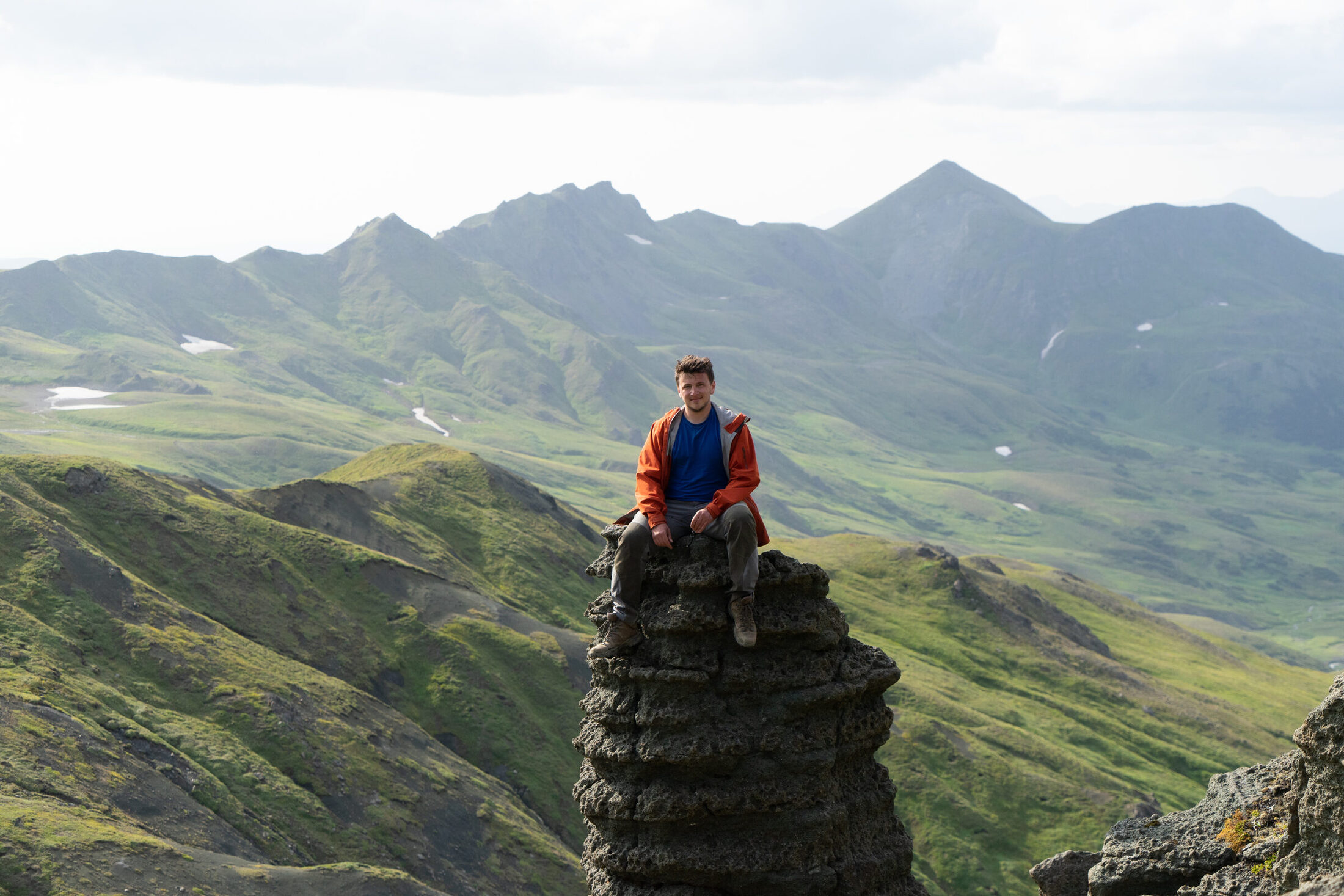 Anton Kutyrev seated in a volcanic mountain landscape.