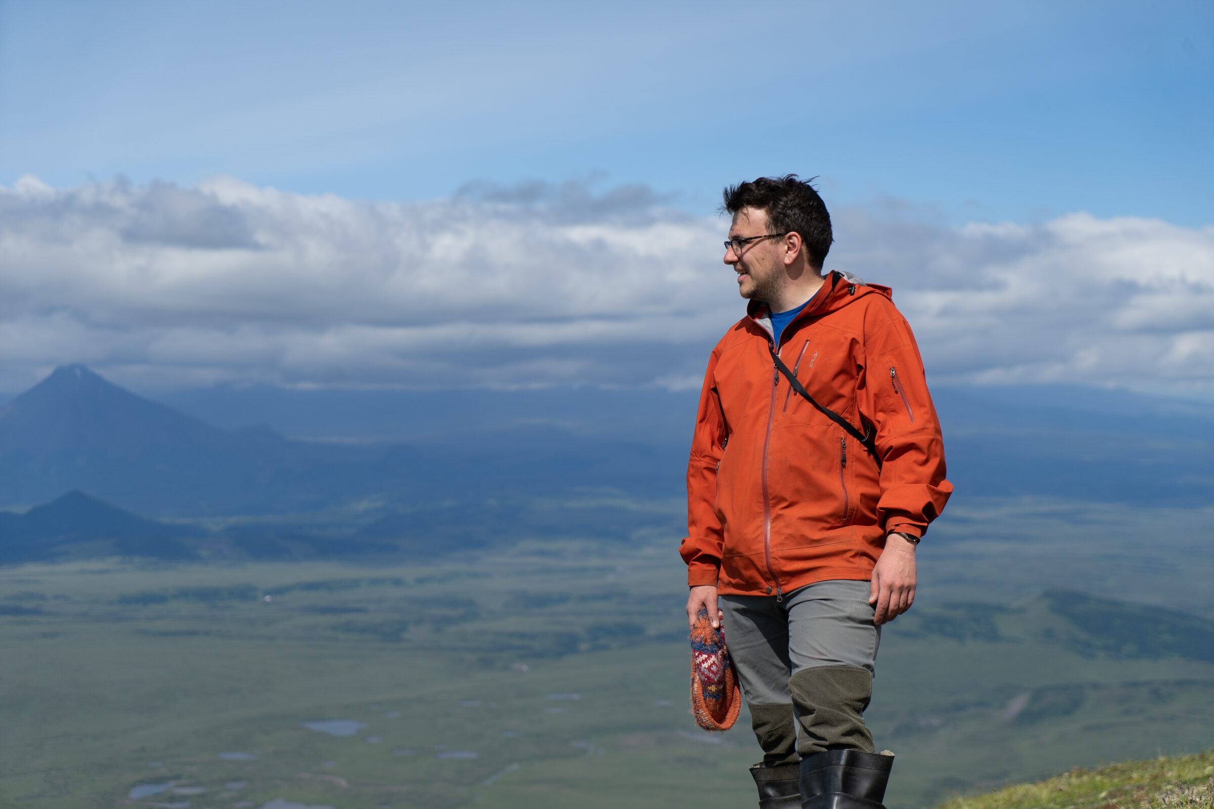 Anton Kutyrev standing in the field in an orange jacket.
